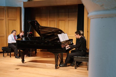 Two students and one teacher in a piano class