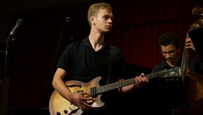 Student playing guitar in a jazz ensemble