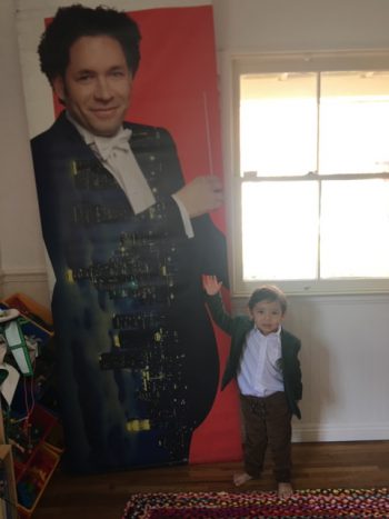 Child next to portrait of Dudamel