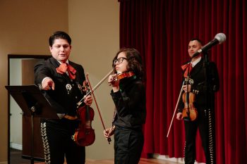 Mariachi instructor and young musician playing violin