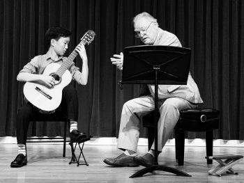 Guitar student with teacher on stage