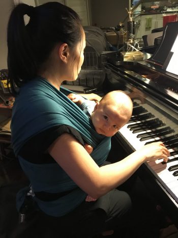 Woman with baby playing piano