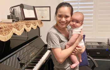 Woman holding baby near piano