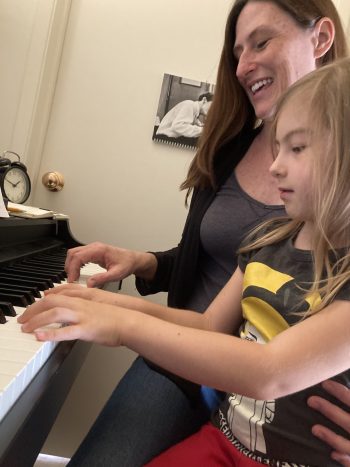 Woman and daughter play piano