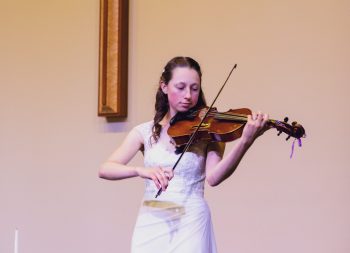 Woman in weddin dress plays viola