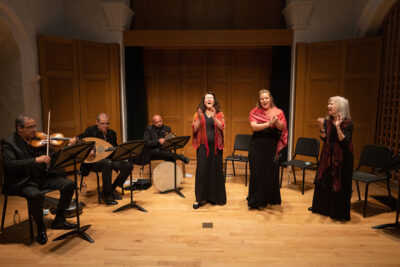 Three singers perform with percussionists