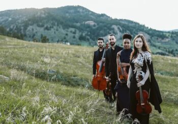 String Quartet out in a field holding their instruments