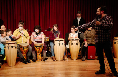 Group of adult and children play drums