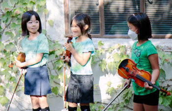 3 girls with violins on stage