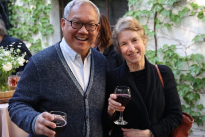 A man and woman pose with wine glasses