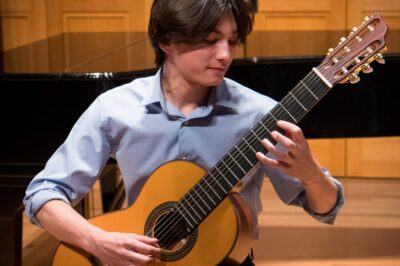 A young man plays guitar