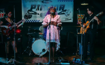 Woman performs onstage with her band