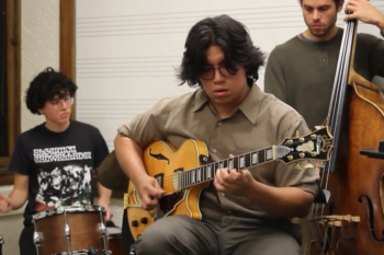 Jazz trio with guitar, drums, and bass.