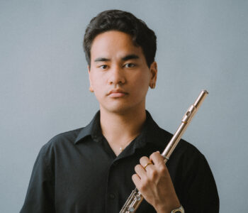 Man in black shirt holds flute