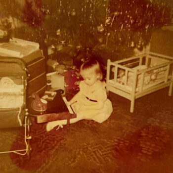 An old photo of a little girl playing a toy piano